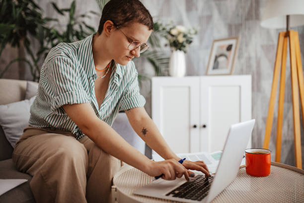 istock Individual typing on laptop at round table with papers 2163734371