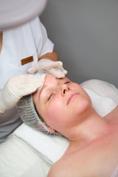 istock Beautician applying cosmetic mask on a customer's face 2163735296