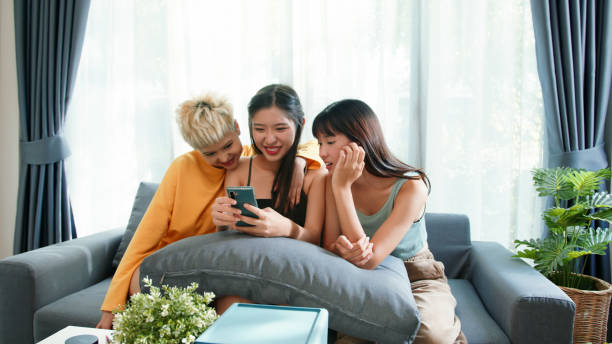 istock Three young Gen z women using a smartphone online shopping on the couch 2163735343