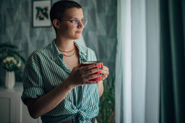 istock Person contemplating while holding red mug indoors. 2163736502