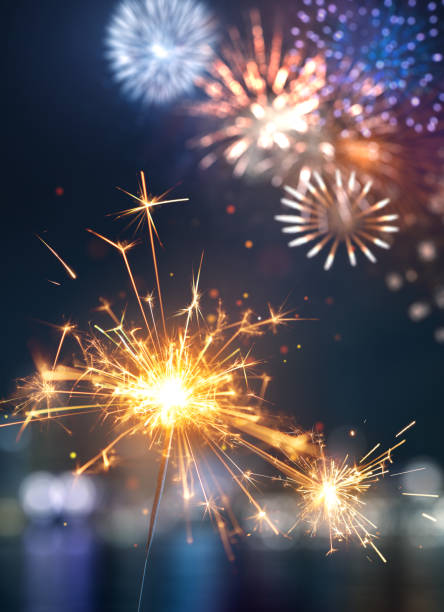 istock Glittering burning sparkler against colorful fireworks background 2163736523