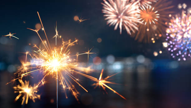 istock Sparkler with blurred fireworks light up the night sky during New Year celebration 2163736524