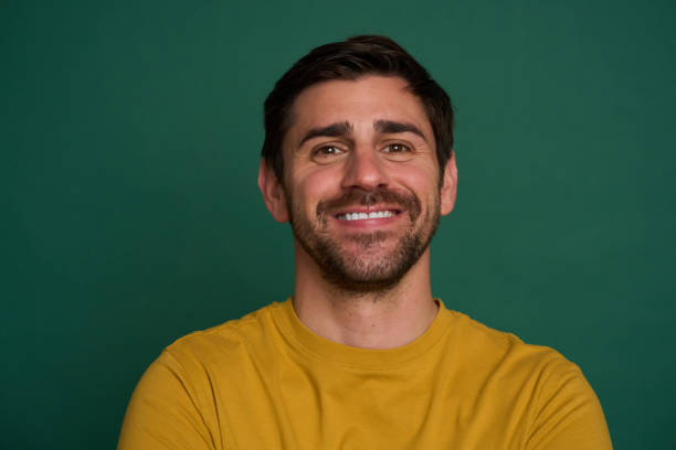 istock Handsome man smiling wearing yellow shirt green background 2163736877