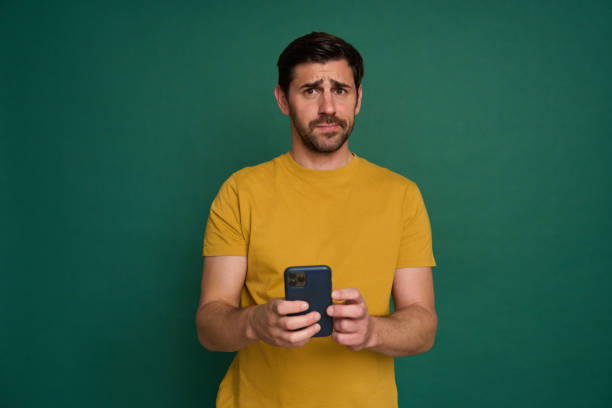 istock Young man reading bad news on his smartphone with a worried expression 2163736977