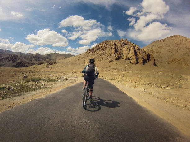 istock A lone female cyclist riding through rugged landscape 2163737292