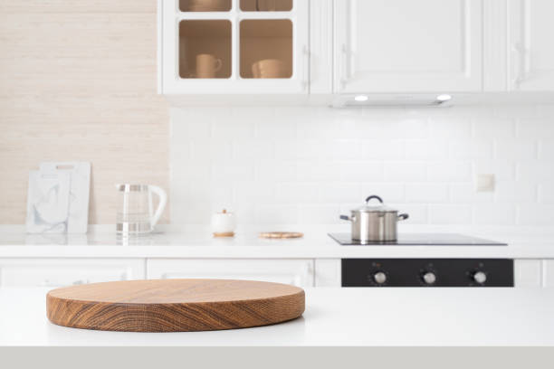 istock Round wooden pedestal on white table with copy space and defocused kitchen counter background 2163737296
