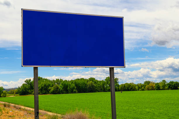 Big Blank Blue Billboard in a Green Field with Sky Background