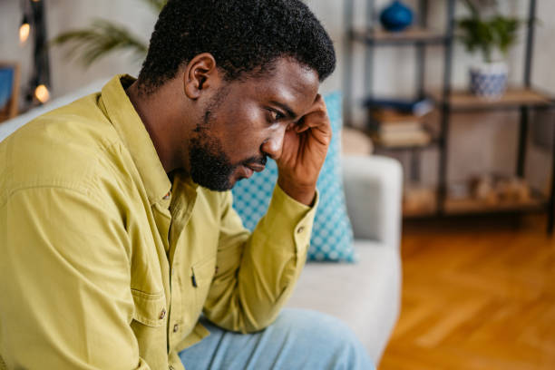 istock Sad Young Man Sitting At Home On The Sofa 2163739348