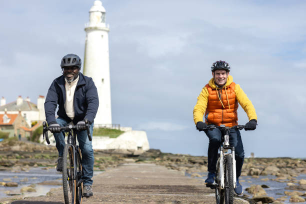 istock Two Friends Cycling along a Lighthouse Path 2163739683