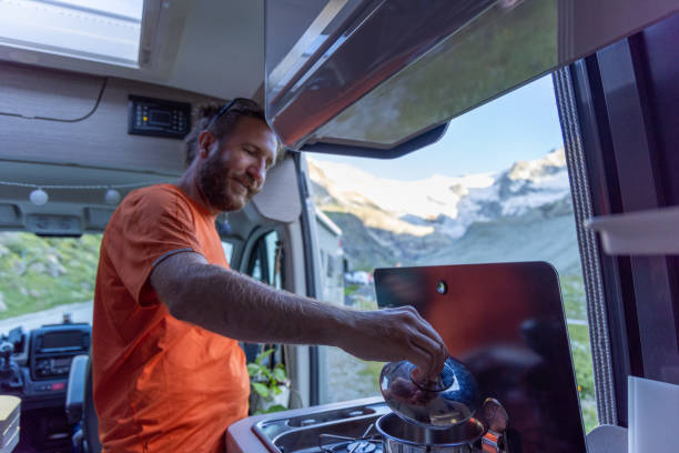 istock Man Cooking in Camper Van with Mountain View 2163739791