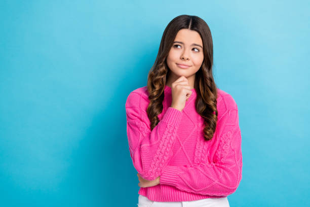 istock Photo of young charming unsure minded thinking look empty space advertisement touch chin choose best offer isolated on blue color background 2163740759