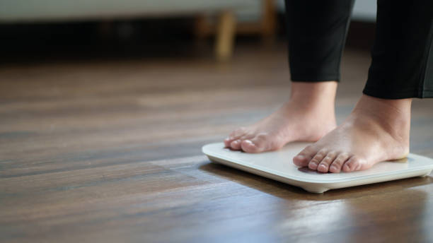 istock Woman feet standing on digital scales for diet control. 2163741436