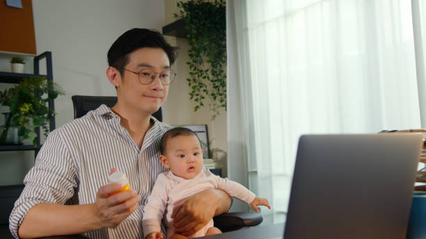 istock Asian Father using telemedicine while holding baby 2163741678