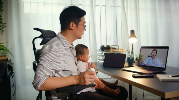 istock Asian Father using telemedicine while holding baby 2163741697