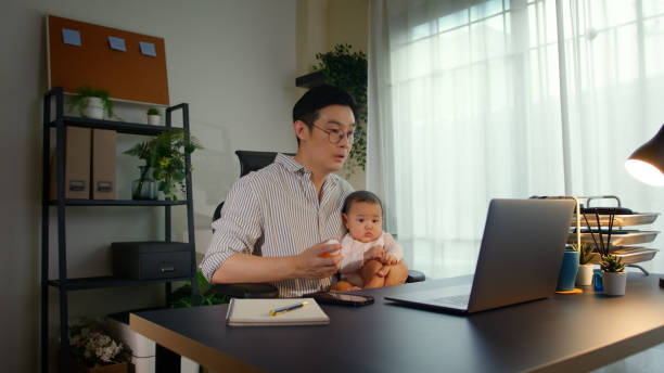 istock Asian Father using telemedicine while holding baby 2163741725