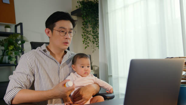istock Asian Father using telemedicine while holding baby 2163741726