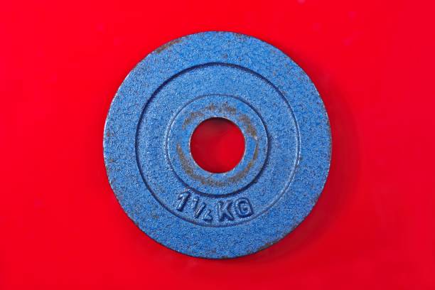 Blue Barbell Weight for sport isolated on red background. Horizontal image.