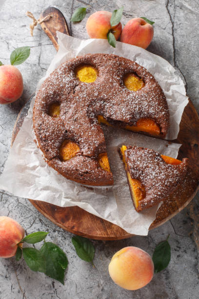 istock Chocolate cocoa pie with fresh peaches close-up on wooden board. Vertical top view 2163746121