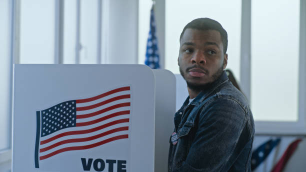 istock African American man stands and decides at voting booth 2163746239