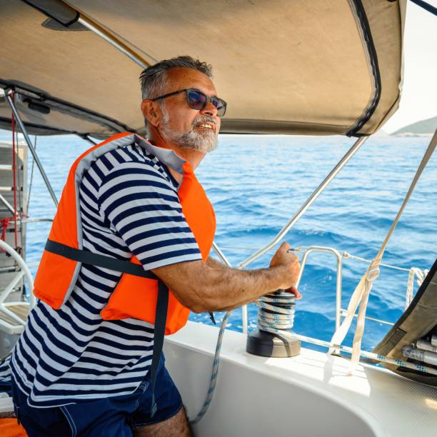 istock Mature man on the sailing boat using a winch 2163748631
