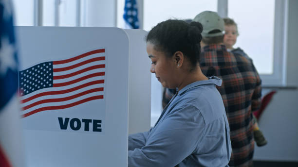 istock Multi cultural American citizens come to voting booth 2163749362