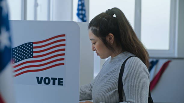istock Multi ethnic American citizens come to vote in booth 2163750759