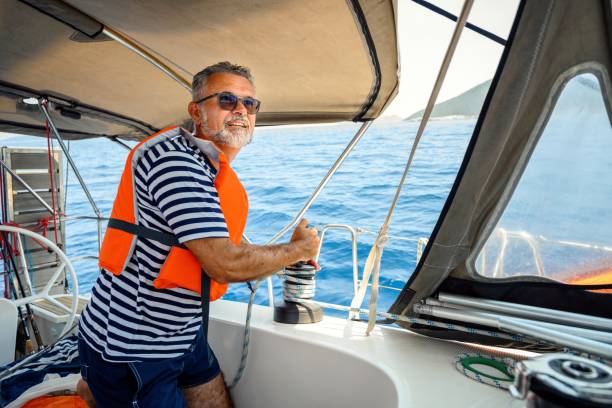 istock Mature man on the sailing boat using a winch 2163750934