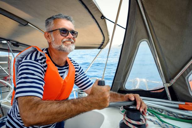 istock Mature man on the sailing boat using a winch 2163751427
