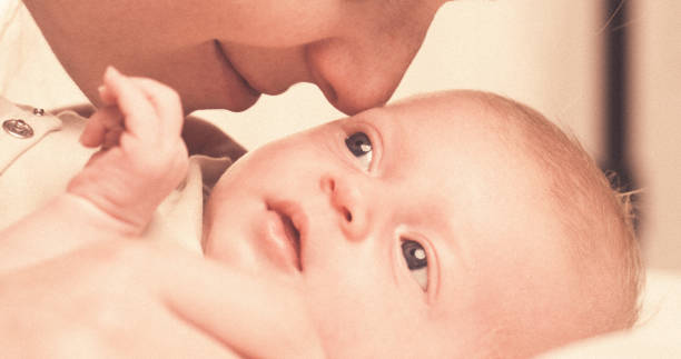 istock Mother rubs baby's nose with her nose. 2163752334
