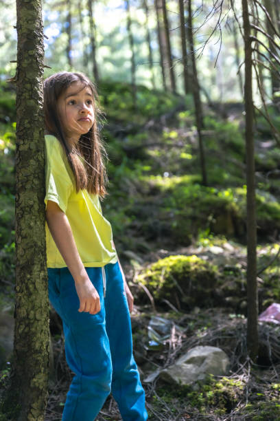 istock Sad girl in a forest polluted by plastic. Nature pollution concept. 2163753281