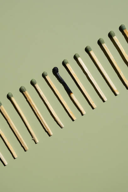 istock Burnt matchstick among unburnt ones on row. 2163755670