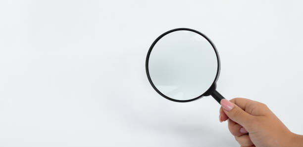 istock Hand holding Magnifying Glass isolated on white background 2163756439