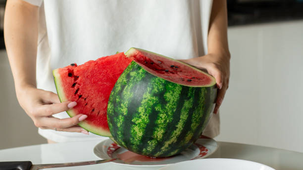 istock Woman slice fresh watermelon at kitchen, closeup 2163756441