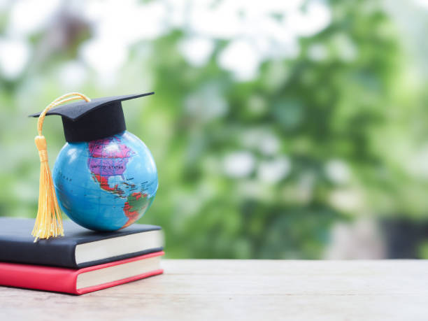 istock Student creative desktop. Earth globe with graduation hat on hardcover book. Copy space for text, Back to school, Education concept 2163759316