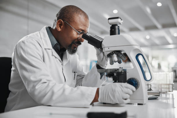 istock Medical, scientist and black man with microscope in lab for research, development and stem cell test. Mature person, science and biotech with review for dna, investigation and growth in vaccine study 2163767430