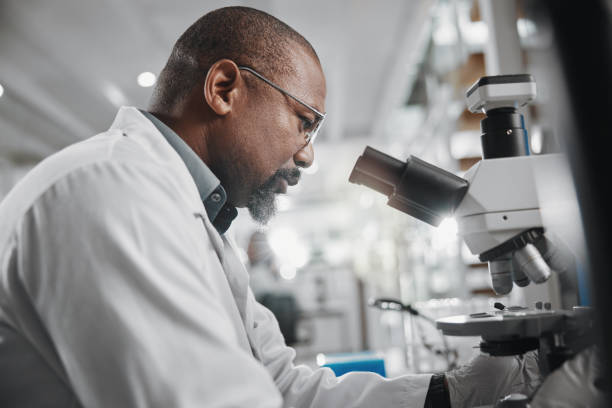 istock Science, lab and microscope research with black man and computer for data analysis and doctor report. Working, scientist and medical journal study with tech and professional with healthcare article 2163767433
