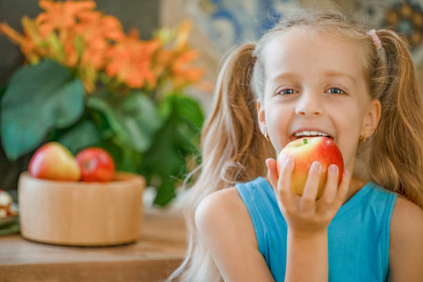 Smiling Girl Holding Apple Over White Background