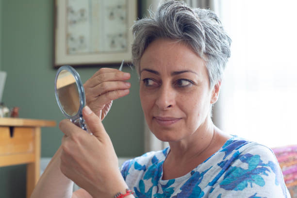 istock Woman plucking eyebrows at home 2163769617