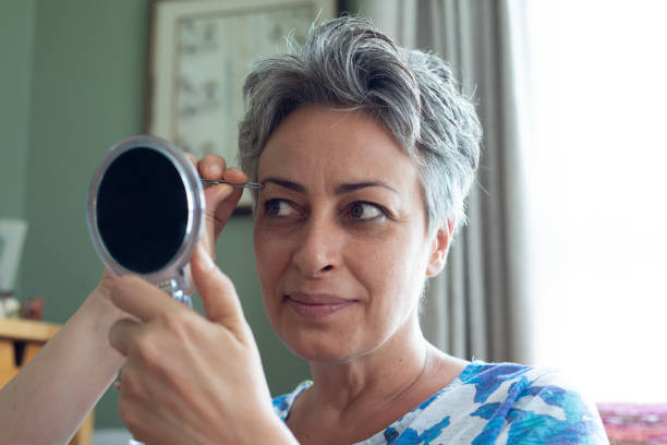 istock Woman plucking eyebrows at home 2163769618