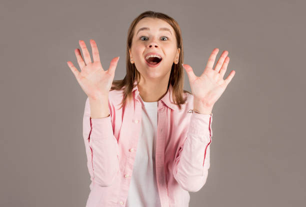 istock Surprised young woman shouting over gray background. Looking at camera 2163773308