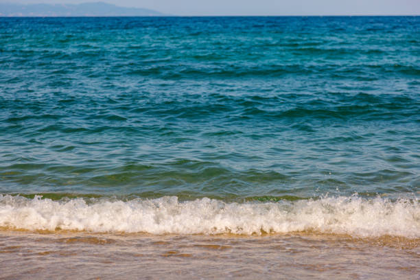 Close-up, front view of waving sea at sunny summer day.