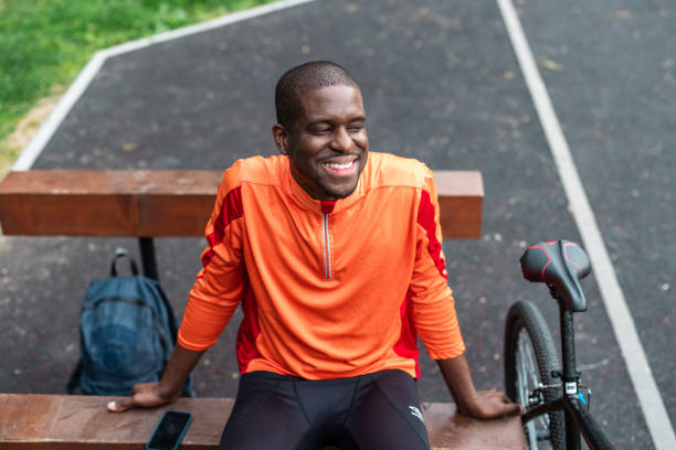istock Smiling man resting on bench after cycling in park 2163777049