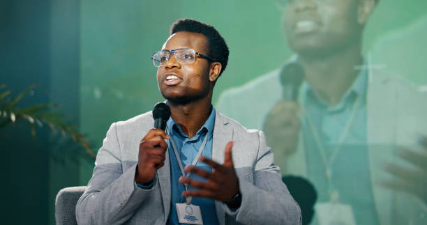 istock Black man, business seminar and speaking for presentation, teaching and discussion at work conference. African presenter, microphone and speech for networking workshop, idea pitch and education forum 2163778262