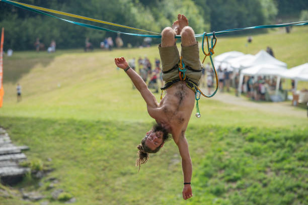 Serina Italy July 21, 2024: Tightrope walker walking on a rope suspended from the ground in a public park