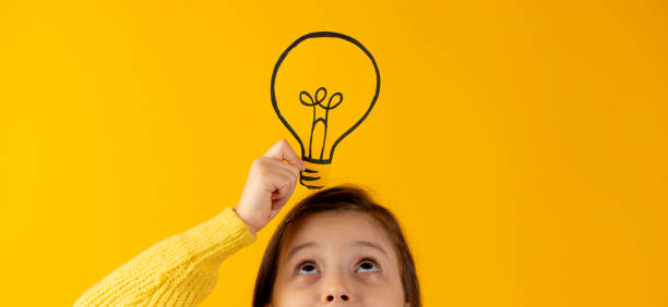 istock Girl Holding Light Bulb On Head 2163784180