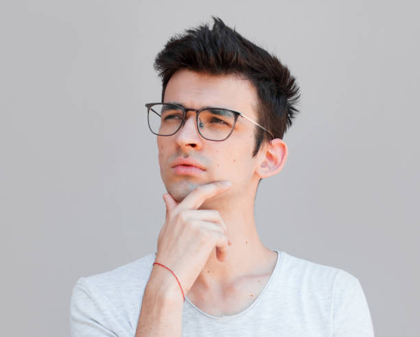istock Young man with white shirt having doubts and with confuse face expression while scratching head on isolated grey background 2163787778
