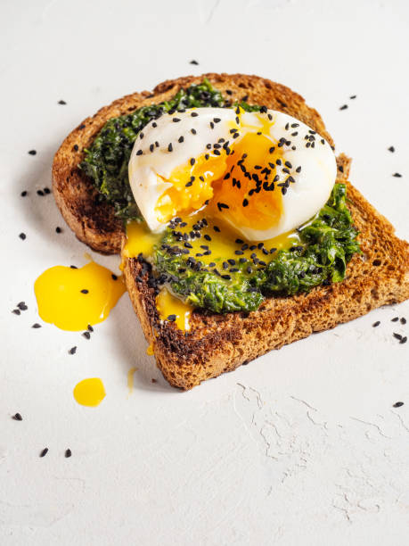 istock Poached eggs on toasted bread. Eggs benedict with spinach. Delicious fresh benedict eggs. 2163788490