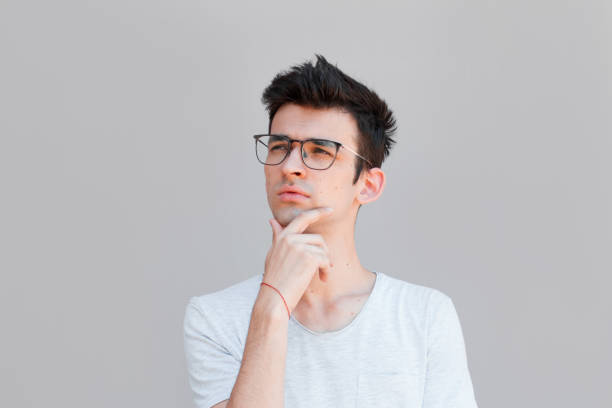 istock Young man with white shirt having doubts and with confuse face expression while scratching head on isolated grey background 2163788960