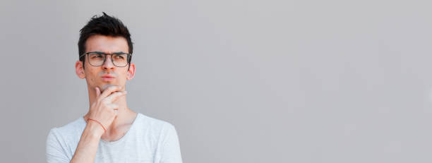 istock Young man with white shirt having doubts and with confuse face expression while scratching head on isolated grey background 2163789884