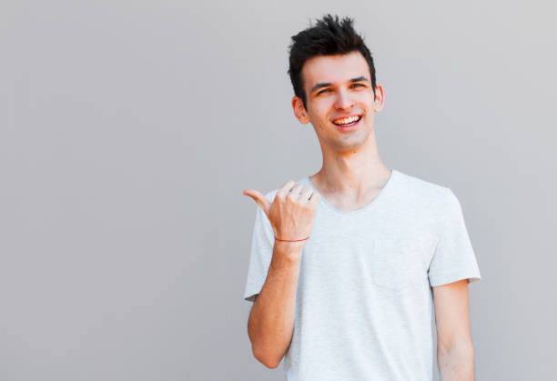 istock Cheerful toothy stylish man pointing with finger. 2163791085